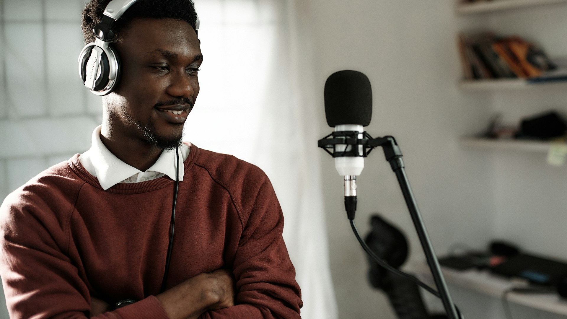 Voice artist recording in professional studio with microphone and headphones