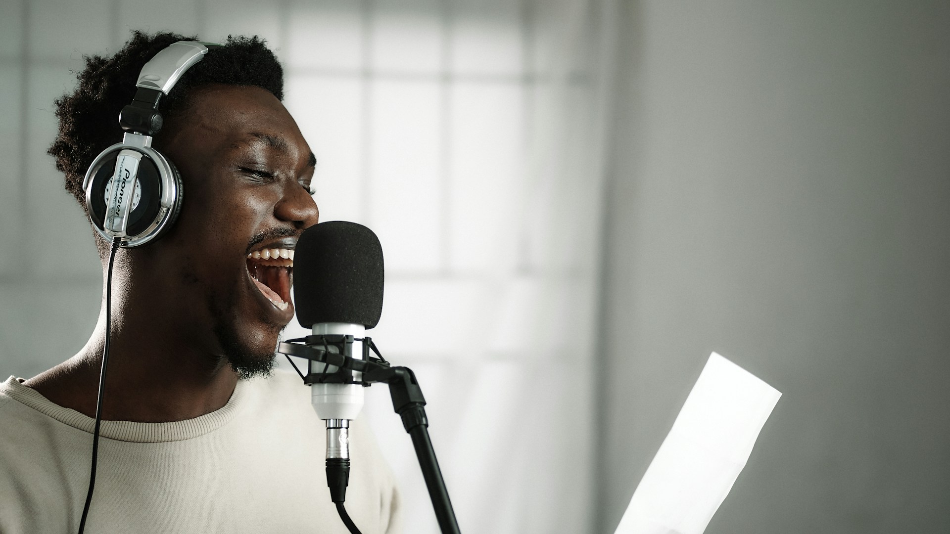 Man with headphones singing into professional microphone
