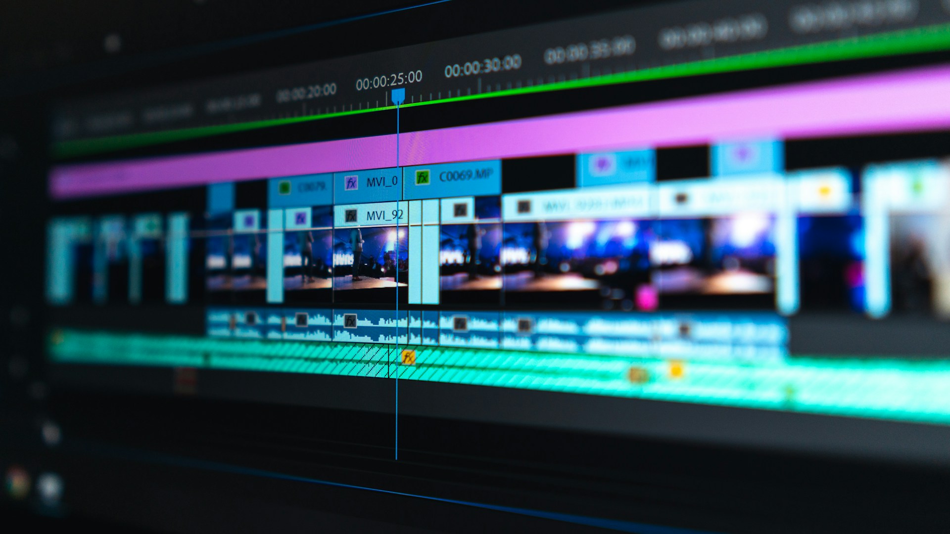 Video editing timeline on a computer screen with audio waveforms and color-graded footage
