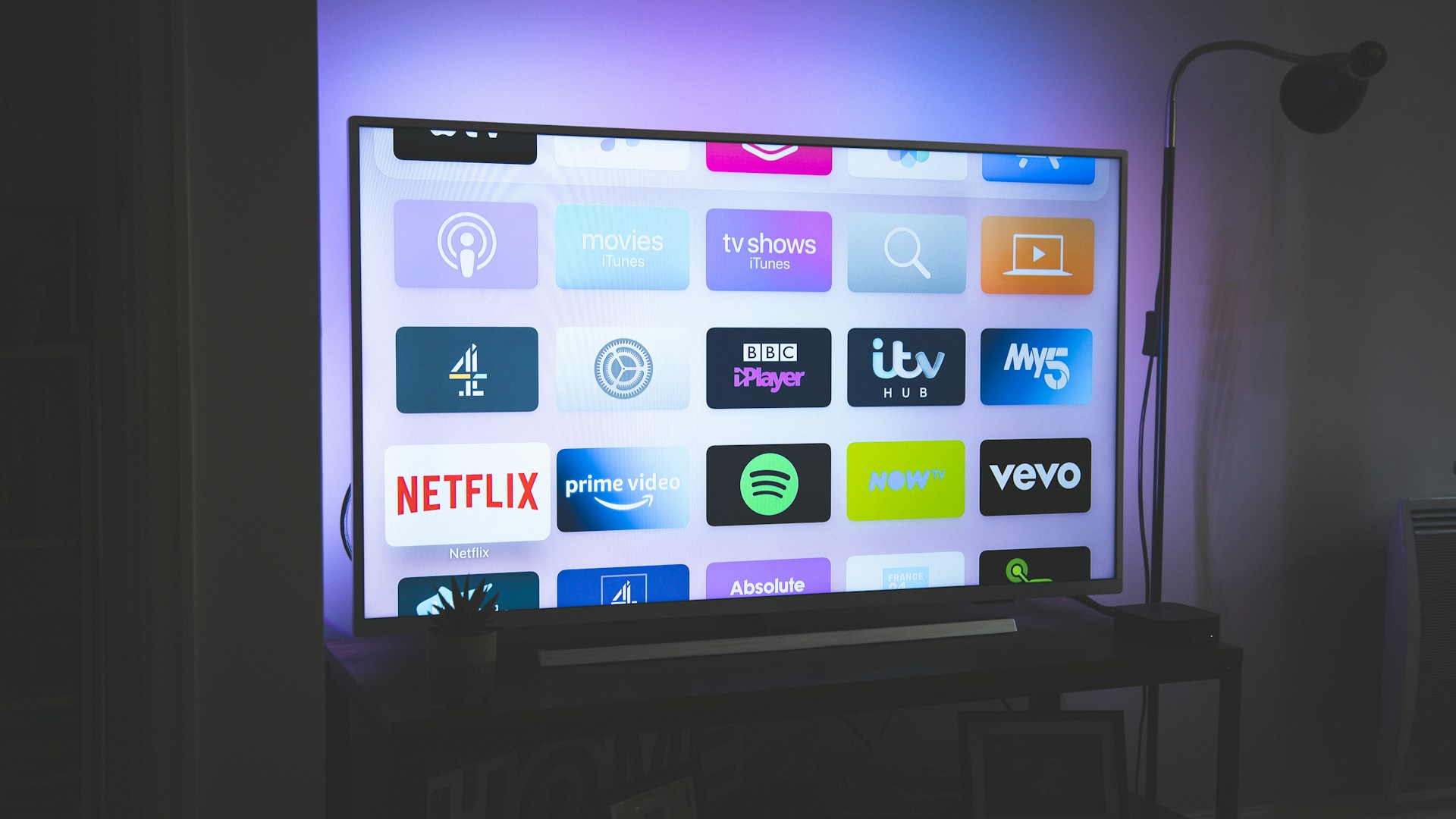Smart TV remote control on a coffee table with TV screen in background